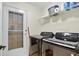 Well-equipped laundry room with modern black washer and dryer, shelving, and convenient access to the outdoors at 2612 Keswick Ct, Kissimmee, FL 34744