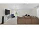 Cozy living room featuring a large sectional sofa, TV, blue armchair, and a window with a pleasant backyard view at 2612 Keswick Ct, Kissimmee, FL 34744