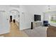 Open-concept living room featuring a large sectional sofa, TV, hallway leading to bar, and view of eat-in kitchen at 2612 Keswick Ct, Kissimmee, FL 34744