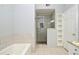 Well lit bathroom featuring shower, tub, shelving, vanity with granite top, and neutral-tone tile at 267 Goldenrain Dr # 30, Celebration, FL 34747