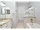 Bathroom with a white dual sink vanity, granite countertop, large mirror and a separated bathtub at 267 Goldenrain Dr # 30, Celebration, FL 34747