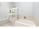 Bathroom featuring vanity with granite top, large mirror, tile floors, and a bathtub at 267 Goldenrain Dr # 30, Celebration, FL 34747