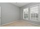 A bright bedroom featuring neutral carpeting and two windows providing natural light at 267 Goldenrain Dr # 30, Celebration, FL 34747