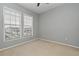 Bedroom featuring neutral carpeting and two windows providing natural light and neighborhood views at 267 Goldenrain Dr # 30, Celebration, FL 34747