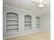 Bright living room featuring three arched built-in bookshelves and a ceiling fan at 267 Goldenrain Dr # 30, Celebration, FL 34747