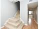 Carpeted staircase with wooden floors, leading to kitchen and hallway with natural lighting at 267 Goldenrain Dr # 30, Celebration, FL 34747