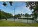 Community tennis courts enclosed by a green fence with a glimpse of houses at 267 Goldenrain Dr # 30, Celebration, FL 34747