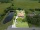 Expansive property with pond, large lawn, mature trees, and well-maintained home, as seen from an aerial perspective at 2695 Hilliard Ct, Kissimmee, FL 34744