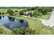 Scenic aerial shot of a home with a private pond, surrounded by verdant lawns, trees, and mature landscaping at 2695 Hilliard Ct, Kissimmee, FL 34744