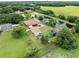 Aerial view captures a private pond with a residence, pool, detached garage and manicured lawns and tree-lined surroundings at 2695 Hilliard Ct, Kissimmee, FL 34744