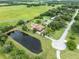Picturesque aerial view of a sprawling property with a tranquil pond, lush landscaping, and a well-maintained home at 2695 Hilliard Ct, Kissimmee, FL 34744