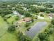An aerial view showcasing a home and its private pond nestled amongst manicured lawns, lush trees, and landscaped surroundings at 2695 Hilliard Ct, Kissimmee, FL 34744