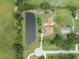Aerial view of a spacious property featuring a tranquil pond, a well-kept lawn, and a charming home at 2695 Hilliard Ct, Kissimmee, FL 34744