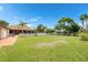 Oversized backyard with a large lawn, mature trees, outdoor patio, and a garden area for relaxation and entertainment at 2695 Hilliard Ct, Kissimmee, FL 34744