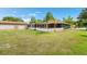 Spacious backyard featuring a large lawn, mature trees, an outdoor patio, and an oversized two-car garage at 2695 Hilliard Ct, Kissimmee, FL 34744