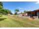 Expansive backyard with lush green grass, mature trees, outbuildings, and a charming patio area for outdoor enjoyment at 2695 Hilliard Ct, Kissimmee, FL 34744