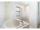 Bright bathroom featuring a soaking tub, a glass-enclosed shower, and tiled flooring at 2695 Hilliard Ct, Kissimmee, FL 34744