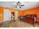 Bright bedroom featuring terracotta tile flooring, a ceiling fan, and a king-size wooden bed with bedding at 2695 Hilliard Ct, Kissimmee, FL 34744