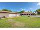 Spacious backyard with well-kept lawn, a detached three-car garage, and a charming house with an inviting patio at 2695 Hilliard Ct, Kissimmee, FL 34744
