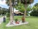 Charming blue home with well-manicured lawn and decorative landscaping featuring palm trees and a white stone garden at 2695 Hilliard Ct, Kissimmee, FL 34744