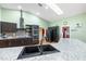 Spacious kitchen features stainless steel appliances, dark cabinets, granite countertops, and natural light from a skylight at 2695 Hilliard Ct, Kissimmee, FL 34744