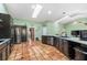 Spacious kitchen with stainless steel appliances, dark cabinets, granite countertops, and skylight, flowing into living area at 2695 Hilliard Ct, Kissimmee, FL 34744