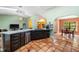 A gourmet kitchen with stainless appliances, granite counters, dark cabinets, and ample natural light in open layout at 2695 Hilliard Ct, Kissimmee, FL 34744