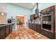 Stylish kitchen with stainless steel appliances, rich cabinetry, tile floors, and seamless flow to dining area at 2695 Hilliard Ct, Kissimmee, FL 34744