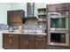 Contemporary kitchen features sleek dark cabinetry, stainless steel appliances, tile backsplash and granite countertops at 2695 Hilliard Ct, Kissimmee, FL 34744