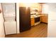 This compact kitchen features a washer and dryer, complementing the wooden cabinetry, countertop, and appliances including a black fridge at 3036 S Semoran Blvd # S, Orlando, FL 32822