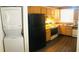 Functional kitchen with wooden cabinets and countertops, appliances including a black refrigerator, an electric stove, and laundry at 3036 S Semoran Blvd # S, Orlando, FL 32822