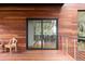 Modern home boasts sliding doors to wood deck with stainless steel railing overlooking nature at 3807 S Semoran Blvd, Orlando, FL 32822