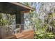 Outdoor deck featuring stainless steel railing, wood accents and views of the surrounding trees and lake at 3807 S Semoran Blvd, Orlando, FL 32822