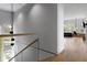 Bright hallway with wood floors, glass railing and a view into the living area at 3807 S Semoran Blvd, Orlando, FL 32822