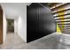 Hallway featuring modern staircase, a door to a bath with marble surround, and concrete floors at 3807 S Semoran Blvd, Orlando, FL 32822