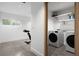 Bright laundry room with modern washer and dryer, built in shelves, and a sleek concrete floor at 3807 S Semoran Blvd, Orlando, FL 32822