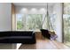Modern living room featuring a swing chair, black couch and windows with views of the trees at 3807 S Semoran Blvd, Orlando, FL 32822