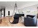 Open living room design with a modern hanging chair, sleek furniture, and expansive windows at 3807 S Semoran Blvd, Orlando, FL 32822