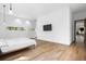 Bright main bedroom featuring hardwood flooring, a sleek television, and sunlit windows at 3807 S Semoran Blvd, Orlando, FL 32822