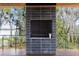 Outdoor black tile fireplace on deck with scenic views of the water and trees beyond at 3807 S Semoran Blvd, Orlando, FL 32822