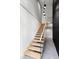 Modern staircase featuring light wood treads, sleek railing, and distinctive black accent wall at 3807 S Semoran Blvd, Orlando, FL 32822