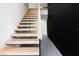 Modern staircase featuring light wood treads, sleek railing, and distinctive black accent wall at 3807 S Semoran Blvd, Orlando, FL 32822