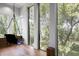 Sunlit view of modern indoor swing chair and expansive windows overlooking lush greenery at 3807 S Semoran Blvd, Orlando, FL 32822