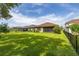 Well-maintained backyard showing a lush lawn, secure black metal fence, and screened-in patio in the background at 3837 Carrick Bend Dr, Kissimmee, FL 34746