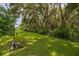 A peaceful, verdant backyard surrounded by mature trees and a secure black fence at 3837 Carrick Bend Dr, Kissimmee, FL 34746