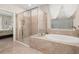 Elegant bathroom featuring a soaking tub with a window view, walk-in shower, and marble tile floors at 3837 Carrick Bend Dr, Kissimmee, FL 34746