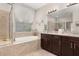 Elegant bathroom featuring a soaking tub with window view, spacious vanity with granite countertops, and marble tile floors at 3837 Carrick Bend Dr, Kissimmee, FL 34746