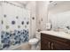 Cozy bathroom with floral shower curtain, single sink vanity and tile flooring at 3837 Carrick Bend Dr, Kissimmee, FL 34746