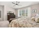 Serene bedroom featuring floral bedding, a ceiling fan, a large dresser with a TV, and ample natural light from a window at 3837 Carrick Bend Dr, Kissimmee, FL 34746