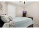 Bright bedroom features a wood-framed bed, tropical-themed pillows, a light blue quilt, and neutral carpeting at 3837 Carrick Bend Dr, Kissimmee, FL 34746
